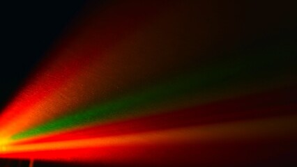 Fototapeta premium Vibrant Red Green and Yellow Light Beams on Dark Background