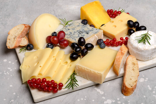 Italian and French gourmet cheese platter with craft cheese assortment on a marble platter. hard cheeses, mold cheese, gorgonzola, pecorino, Emmental, Roquefort cheddar