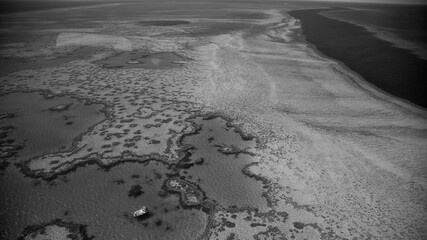Monochrome aerial landscape showing Queensland ocean waters and intricate natural reef formations