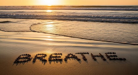 Inspirational message created in sand on a calm beach at sunset with gentle waves lapping the shore