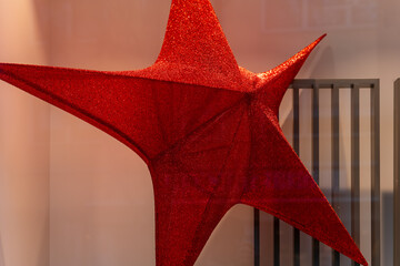 Large red glittery star sculpture displayed in a modern setting during the festive season