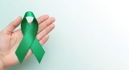 Show of support with a green ribbon held in a hand representing awareness and advocacy for mental health issues during a campaign event