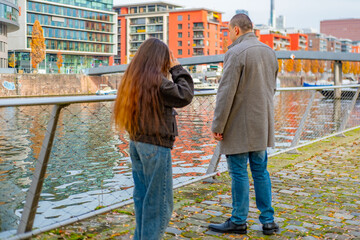 Young couple walking European city, Rear view frustrated couple arguing or having serious conversation, man and long-haired woman, partner conflict, relationship problems, communication breakdown