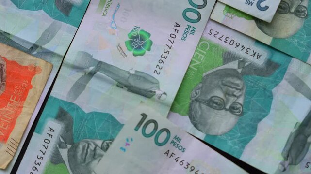 Detailed macro close-up of Colombian pesos banknotes showcasing vibrant currency designs and denominations under soft lighting. Ideal for financial and economic content, emphasizing texture.