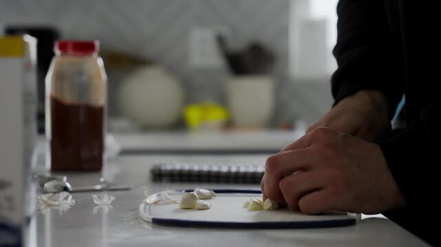 Close-up view of hands chopping garlic with knife for the delicious Beef Qebapa. Traditional Albanian Dish.