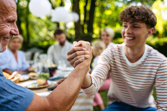 Grandson greeting his grandfather during garden party.