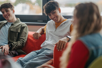 Classmates relaxing and talking in high school lounge.