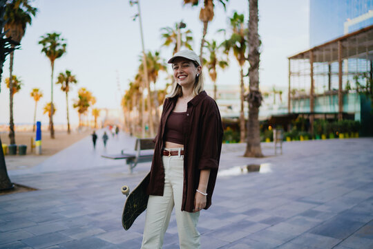 Female subject holds phone in hand, gazing into distance with relaxed confidence, reflecting digital identity and mobile presence.