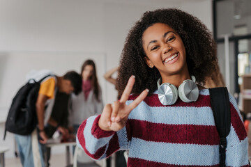 Confident teen student standing in modern classroom.