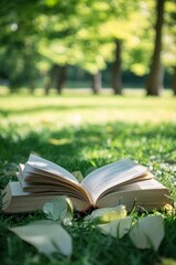 Open book lying on grass in nature, light green and white background with soft lighting for reading and relaxation concept.