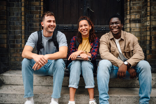 Happy students smiling and relaxing on university steps