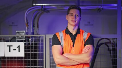 Professional electrician stands in technical environment, showing confidence and pride. Prepared for work, conveying dependability and skill. Calm and satisfied expression.