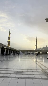 The Prophet&rsquo;s Mosque in Medina, its towering minarets, domes reflected on the white marble courtyard&mdash;a tranquil sunset scene at Al-Masjid an-Nabawi, and worshippers gathered in quiet reflection.