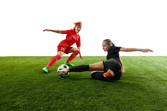 Female football players competing for ball in intense sliding tackle moment. Concept of match coverage, defensive skills training, coaching materials, sports promotion.