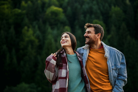 Happy couple enjoying nature smiling in forest