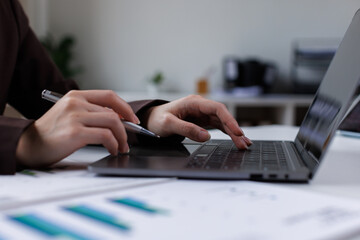 Data analysis interface database. Analyst information system. Business technology research. A person is using a laptop on a desk with a calendar in front of them.