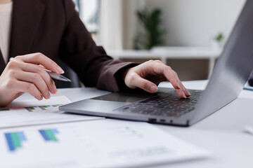 Data analysis interface database. Analyst information system. Business technology research. A person is using a laptop on a desk with a calendar in front of them.