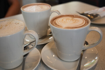 Three Cups of Coffee with Latte Art on Café Table