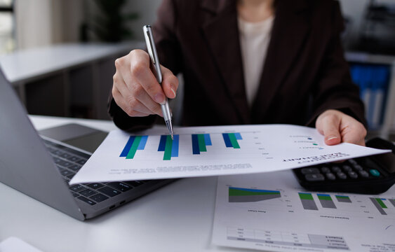 financial officer checking calculator with paper documents to review business annual report in office

