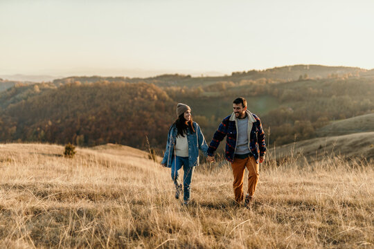 Couple hiking holding hands enjoying autumn nature outdoors