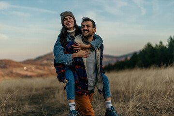 Couple piggybacking outdoors experiencing fun and togetherness