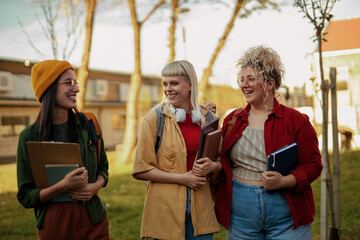Diverse female students laughing walking on campus