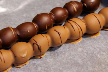 Closeup of two milk and dark chocolate coated grape dessert skewers at a festive christmas or advent market.