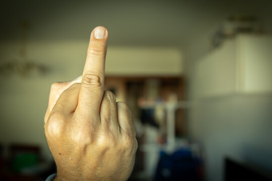 Gesto ofensivo y obsceno del dedo medio levantado en un primer plano.