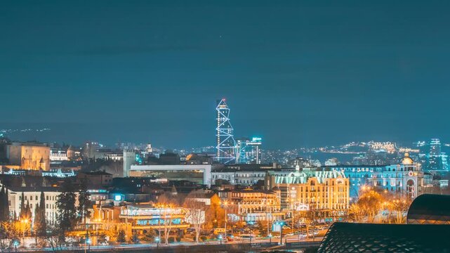 Tbilisi, Georgia. Elevated View Tbilisi Skyline During Sunset Time. 4k Timelapse Radisson Blu Hotel On Background Of Urban Cityscape During Sunset Evening Lights. View Near Tbilisi Music Thaeter And