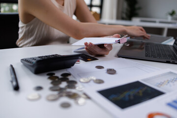 Business woman hand freelancer managing finances and calculating costs at home office, working remotely.Technology of financial Bill pay concept.