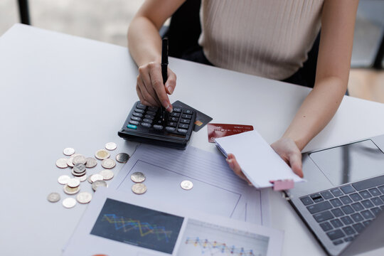 Stressed business woman, employee using calculator to calculate expenses of monthly, hand holding bills and receipt for to payment on table at home. Financial, finance of banking concept
 - Powered by Adobe