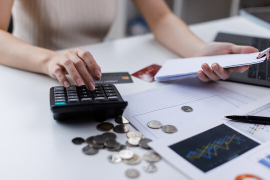 Stressed business woman, employee using calculator to calculate expenses of monthly, hand holding bills and receipt for to payment on table at home. Financial, finance of banking concept
