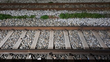 railroad tracks with gravel ballast and green grass