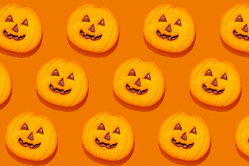 Halloween pumpkin cookies pattern on orange background