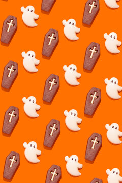 Ghosts and coffins on vibrant orange Halloween cookies