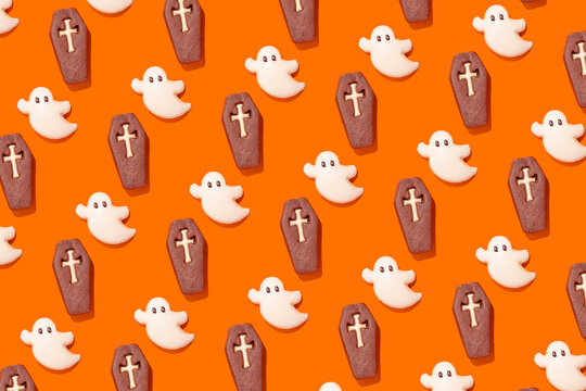 Halloween themed ghost and coffin cookies on orange