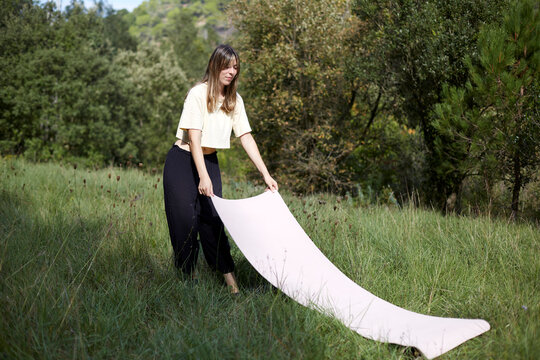 Woman preparing meditation space in the lush forest