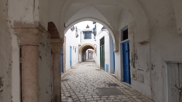 Walking through covered market and bazaar in the early morning, as shops are still closed, in historic medina of Tunis in Tunisia
