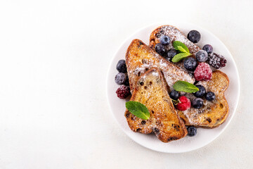 Leftover Christmas Spiced Stollen French Toasts, sweet fried stollen toasts with sugar powder and berries, Christmas morning dessert snack