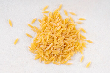 Raw uncooked orzo pasta, Italian dry pasta risoni orzo in bowl on table, copy space