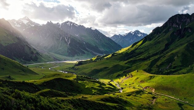 A majestic mountain landscape bathed in dramatic sunlight, featuring rolling green hills, a meandering river, and distant snow-covered peaks. - Powered by Adobe