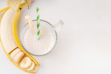 Sweet and tasty traditional korean banana milk. Korean banana uyu, banana flavored non-dairy milk or condensed milk with honey on white table copy space