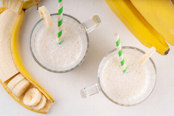 Sweet and tasty traditional korean banana milk. Korean banana uyu, banana flavored non-dairy milk or condensed milk with honey on white table copy space