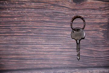 A key on the wooden background. Key on a table