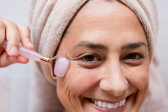 Woman using jade roller for skincare routine