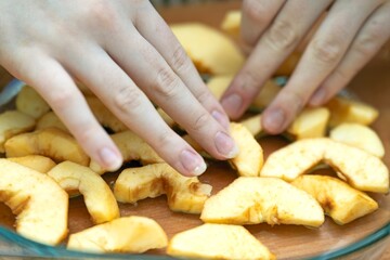 Arranging sliced apple segments in a glass bowl for making a traditional Charlotte pie