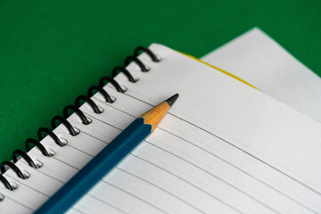 Blank notebook and a calendar Working table with keyboard and notepad, pen, pencil and plant in home office. top view 