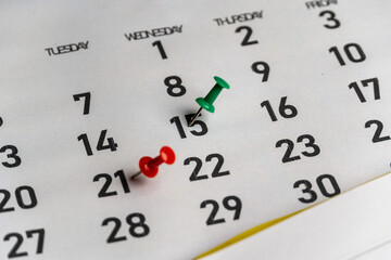 Obraz premium Push-pin in calendar with a blank notebook and pencil kept on a world map to decide date and location for vacation 