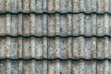 Texture of old worn concrete roof tiles surface, weathered architectural background.