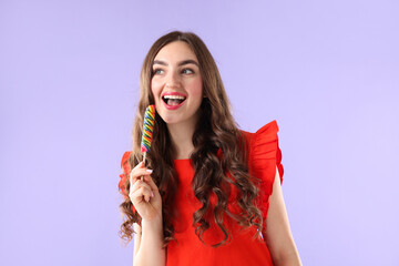 Naklejka premium Beautiful woman with lollipop on violet background